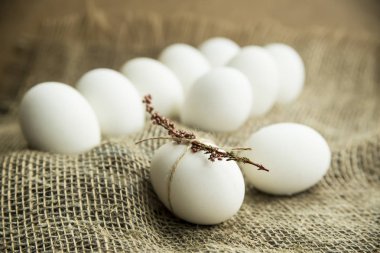 Beyaz yumurta kuru çiçekler ve pembe ip ile dekore edilmiş