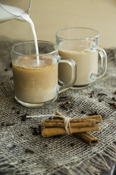 Masala-Tee mit Milch und Gewürzen - Zimt, Nelken, Pfeffer, Kardamom und Ingwer — Stockfoto
