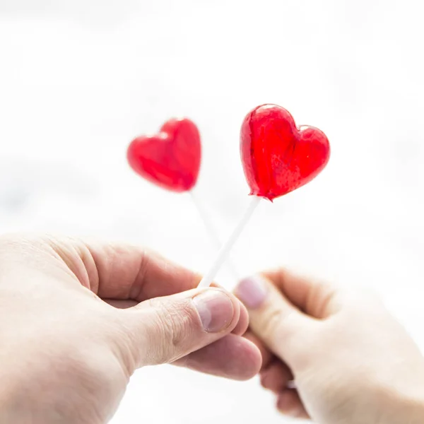 Corazones de caramelo en las manos de un hombre y una niña. un símbolo de amor — Foto de Stock