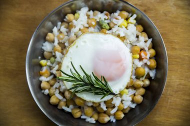 Küçük bir nohut, pirinç ve biberiye ile bir tavada kızarmış yumurta