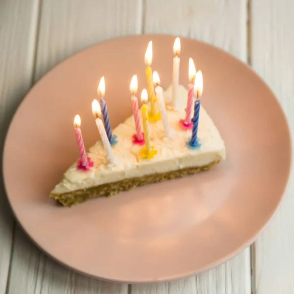 Pedaço de bolo de aniversário para o meu aniversário com uma vela em um prato rosa — Fotografia de Stock