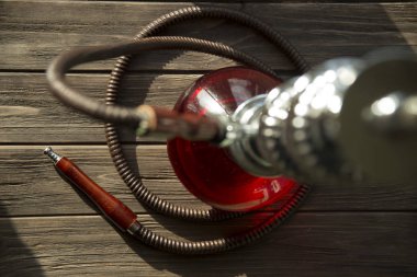 Nargile ahşap bir masa üzerinde. tüp, kase, kömürler, maşa ve ampul. tüm detayları nargile hazırlanması için. meyve