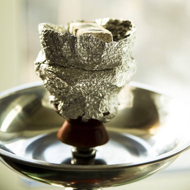 Nargile ahşap bir masa üzerinde. tüp, kase, kömürler, maşa ve ampul. tüm detayları nargile hazırlanması için. meyve