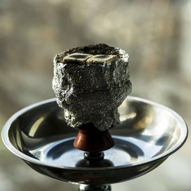 Nargile ahşap bir masa üzerinde. tüp, kase, kömürler, maşa ve ampul. tüm detayları nargile hazırlanması için. meyve