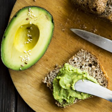 Avokado ekmek Greceanii yapıştırırken bir bıçakla yaymak