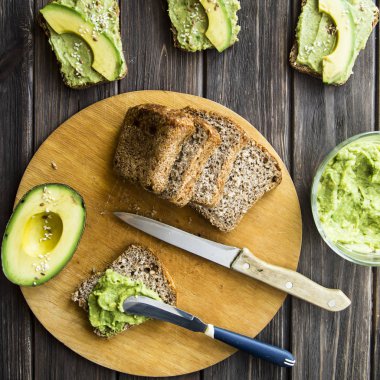 Avokado ekmek Greceanii yapıştırırken bir bıçakla yaymak
