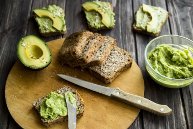 Avokado ekmek Greceanii yapıştırırken bir bıçakla yaymak