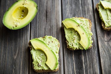 Avokado ekmek Greceanii yapıştırırken bir bıçakla yaymak