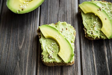 Avokado ekmek Greceanii yapıştırırken bir bıçakla yaymak