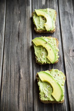 Avokado ekmek Greceanii yapıştırırken bir bıçakla yaymak