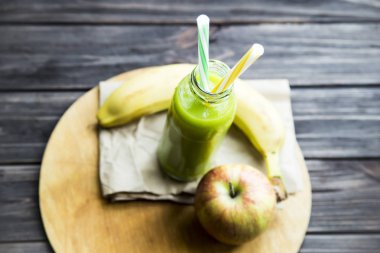 ham elma ve muz sarı ve yeşil bir tüp ile şeffaf şişede taze meyve suyu