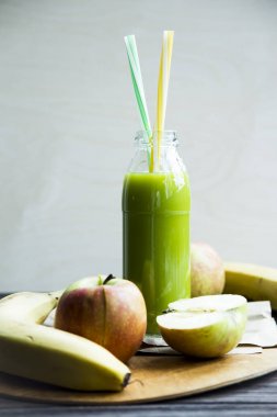 ham elma ve muz sarı ve yeşil bir tüp ile şeffaf şişede taze meyve suyu