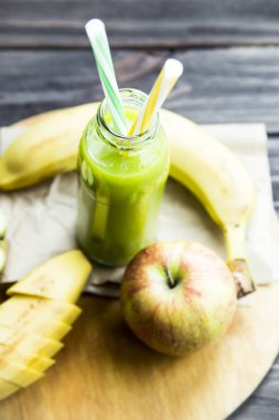 ham elma ve muz sarı ve yeşil bir tüp ile şeffaf şişede taze meyve suyu