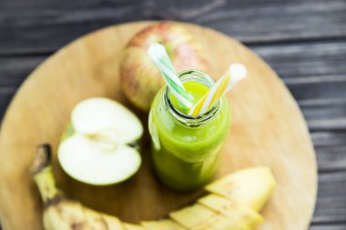 ham elma ve muz sarı ve yeşil bir tüp ile şeffaf şişede taze meyve suyu