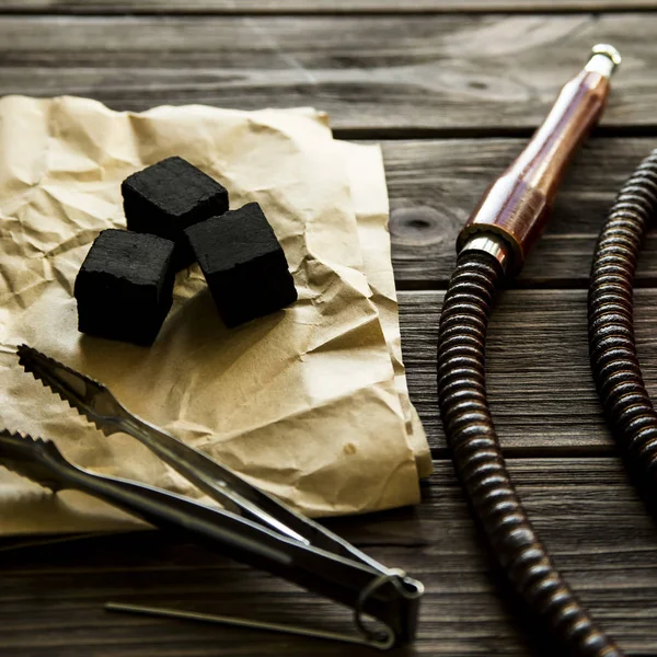 Narguile en una mesa de madera. tubo, cuenco, carbones, pinzas y bombilla — Foto de Stock