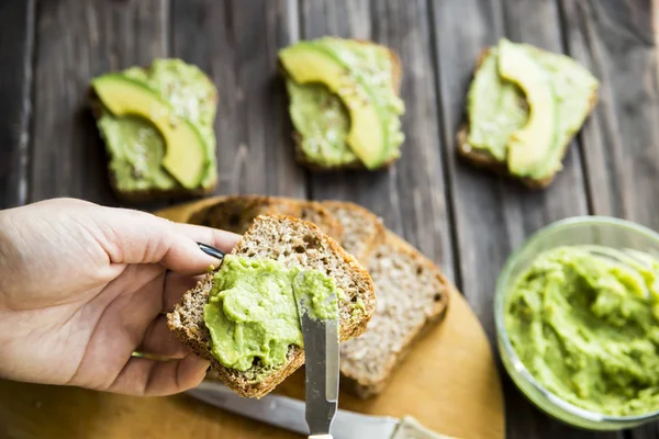 Avokado ekmek Greceanii yapıştırırken bir bıçakla yaymak