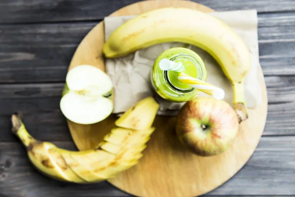 Vers sap van rauwe appels en bananen in een doorzichtige fles met een gele en groene buizen — Stockfoto