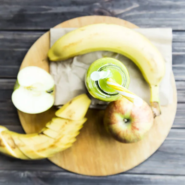 Vers sap van rauwe appels en bananen in een doorzichtige fles met een gele en groene buizen — Stockfoto