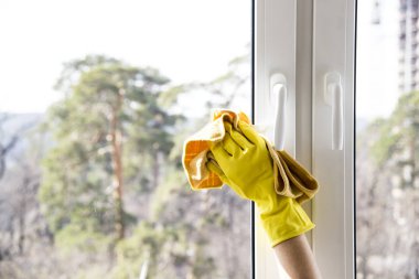 Pencere temizleme. Sarı eldiven eller