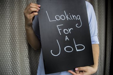 Onun elinde bir işareti ile kız bir gömlek. Bir iş arıyorum