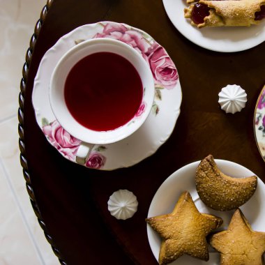 Pembe tatlılar. Bir yuvarlak masa üçte geleneksel aile çay