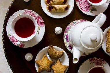 Pembe tatlılar. Bir yuvarlak masa üçte geleneksel aile çay