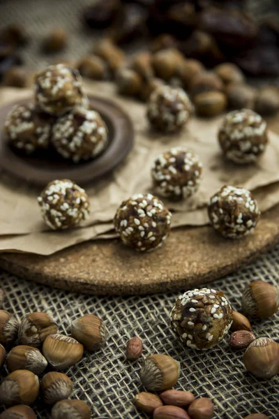 Boulettes crues de dattes et de farine de noix dans les graines de lin tordues — Photo