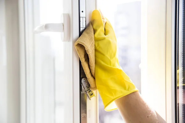 Nettoyage des fenêtres. Mains féminines en gants jaunes — Photo