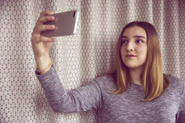 Una joven con el pelo oscuro hace selfie en su teléfono inteligente — Foto de Stock