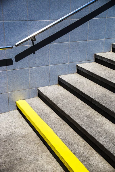 Graue Stufen des Fußgängerüberwegs mit Geländer und Mauer mit Fliesen — Stockfoto