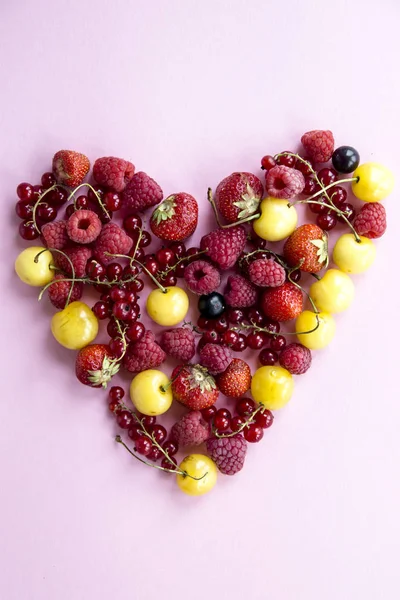 Las bayas de verano están forradas con grosellas en forma de corazón, cerezas, frambuesas y fresas. — Foto de Stock