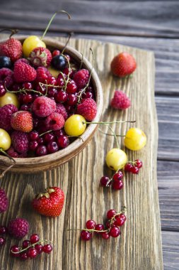 Yaz meyveleri bir kil kase bir ahşap stand