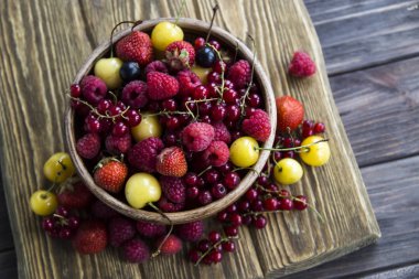 Yaz meyveleri bir kil kase bir ahşap stand