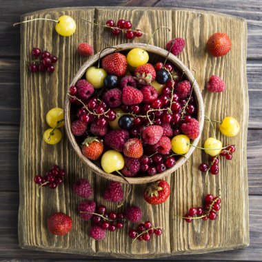 Yaz meyveleri bir kil kase bir ahşap stand