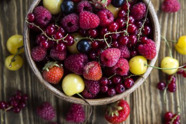 Yaz meyveleri bir kil kase bir ahşap stand