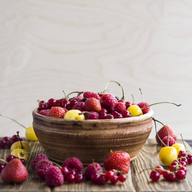 Yaz meyveleri bir kil kase bir ahşap stand