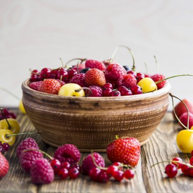 Yaz meyveleri bir kil kase bir ahşap stand