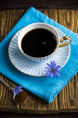 Sıcak bir içecek bir fincan yanındaki mavi hindiba çiçek