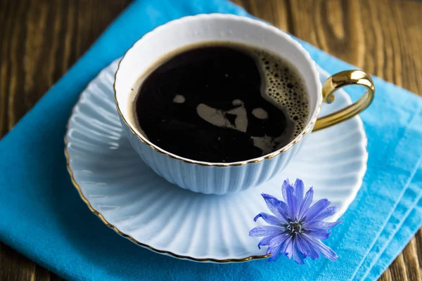 Fiori di cicoria blu accanto a una tazza di bevanda calda — Foto Stock