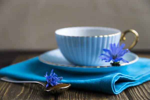 Flores de achicoria azul junto a una taza de bebida caliente — Foto de Stock