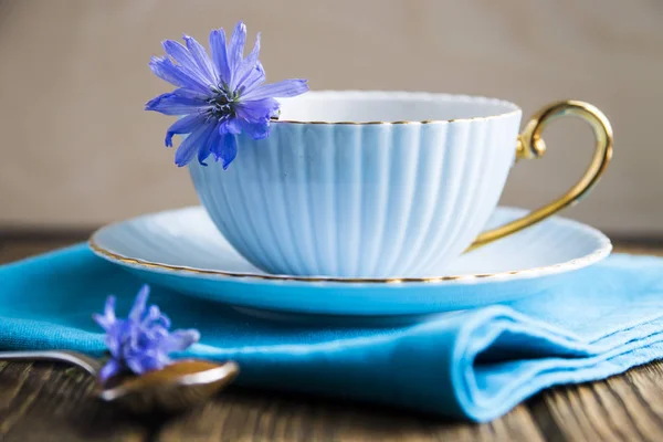 Kwiaty niebieskie cykorii obok filiżankę gorącego napoju — Zdjęcie stockowe
