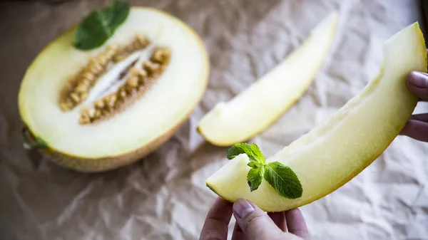 Melón rebanado junto con menta en un soporte de madera — Foto de Stock