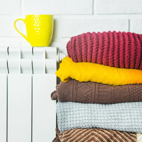 Una batería caliente y suéteres multicolores para no congelarse en invierno —  Fotos de Stock