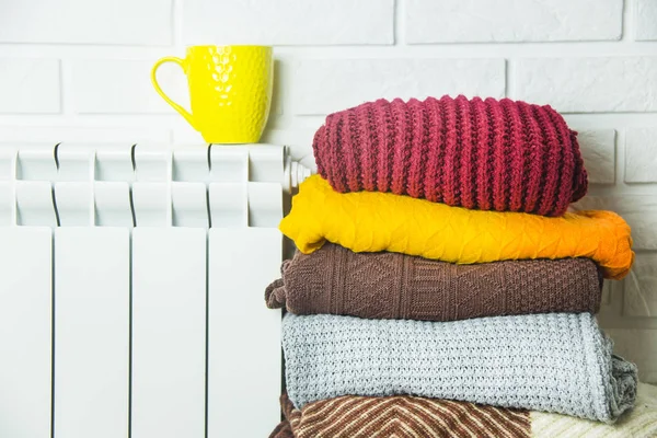 Una batería caliente y suéteres multicolores para no congelarse en invierno —  Fotos de Stock