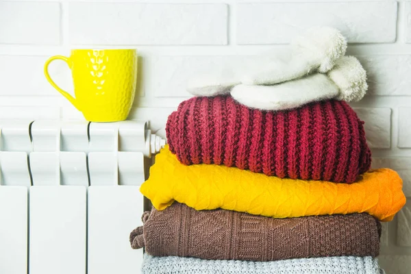 Una batería caliente y suéteres multicolores para no congelarse en invierno —  Fotos de Stock