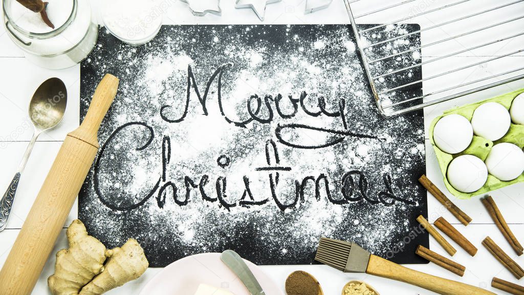 Merry Christmas. written on a black board sprinkled with flour. Christmas cooking concept
