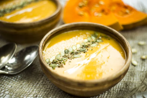 balkabağı çorbası bir kil tabak kabak çekirdeği, susam, baharat ve krema ile dekore edilmiş