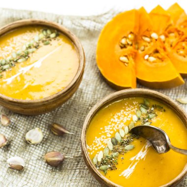 balkabağı çorbası bir kil tabak kabak çekirdeği, susam, baharat ve krema ile dekore edilmiş