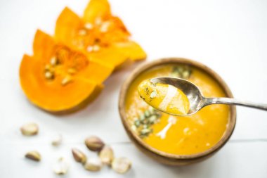 balkabağı çorbası bir kil tabak kabak çekirdeği, susam, baharat ve krema ile dekore edilmiş