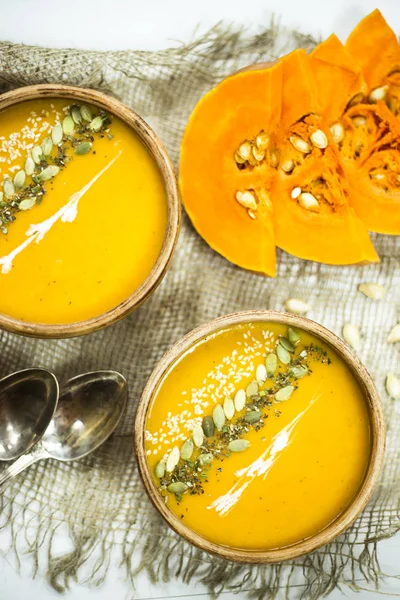 balkabağı çorbası bir kil tabak kabak çekirdeği, susam, baharat ve krema ile dekore edilmiş